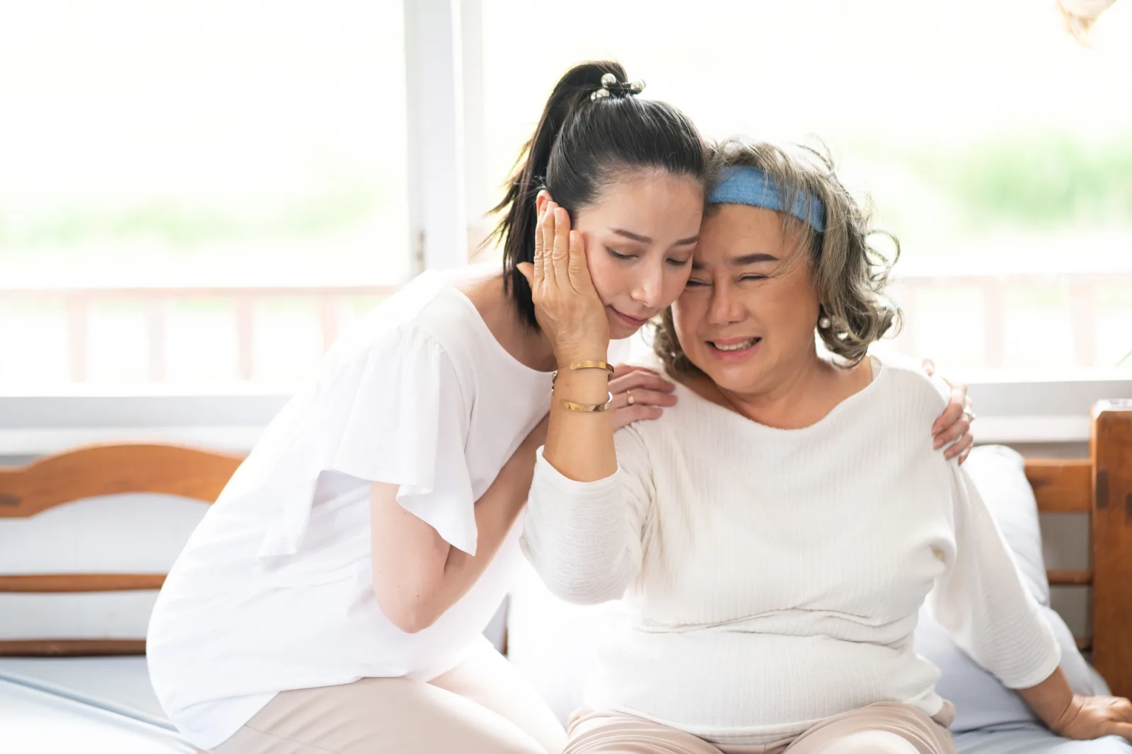 Senior woman with carer hugging