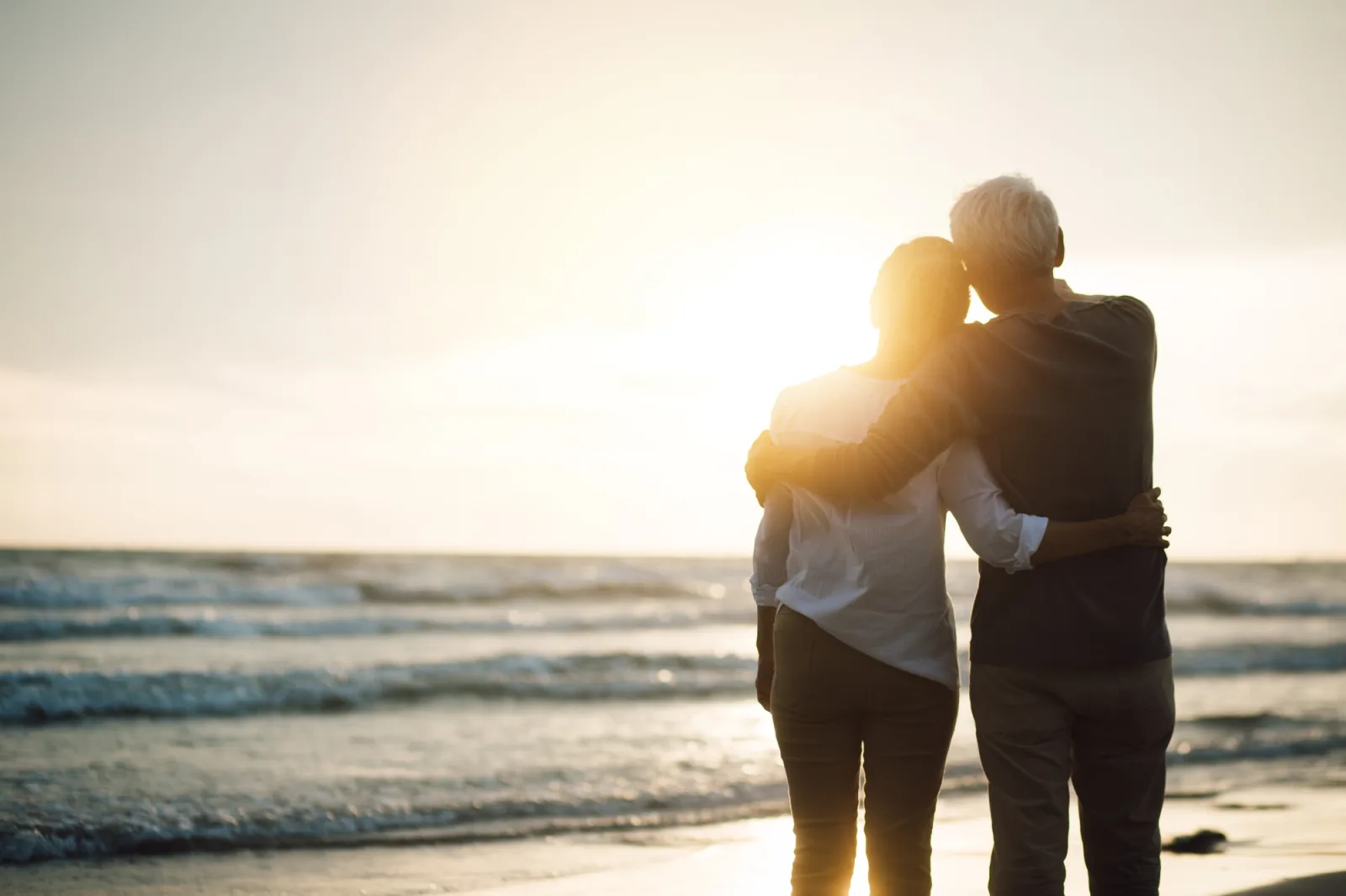 Senior couple looking at the sunset on the beach