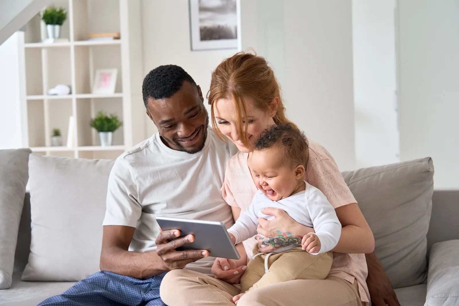 Family sitting on lounge looking at ipad