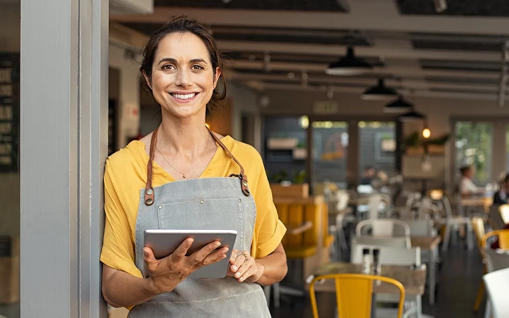 Small business owner smiling and working in cafe