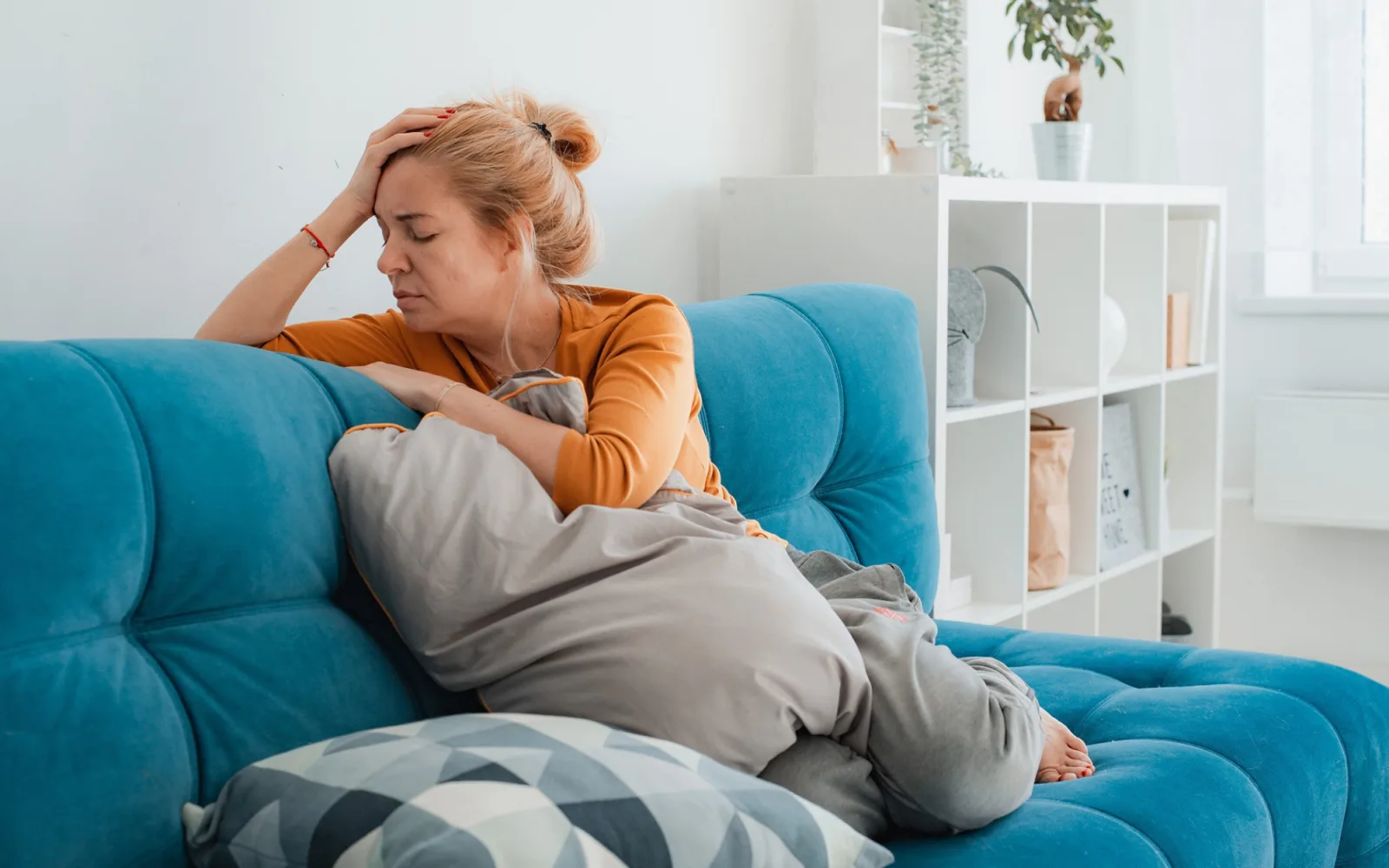Pensive woman sitting on couch