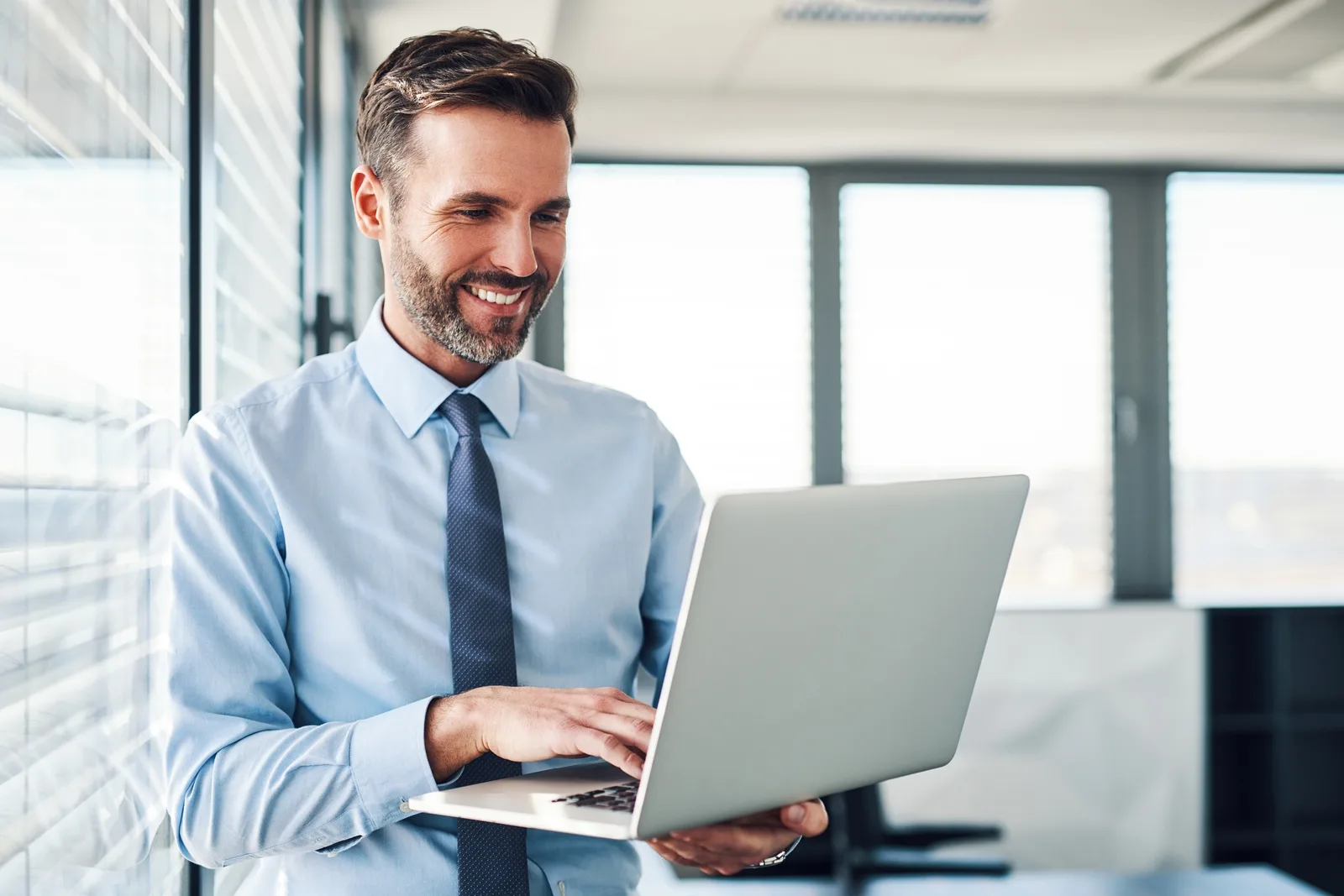 Smiling businessman working on laptop