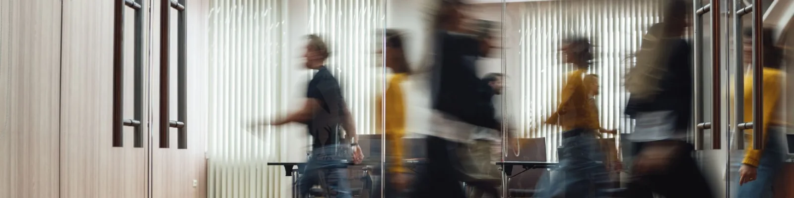 Office meeting room with blurred silhouette of people walking by