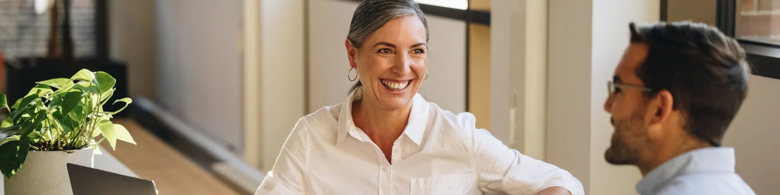 Employees sitting at office desks smiling