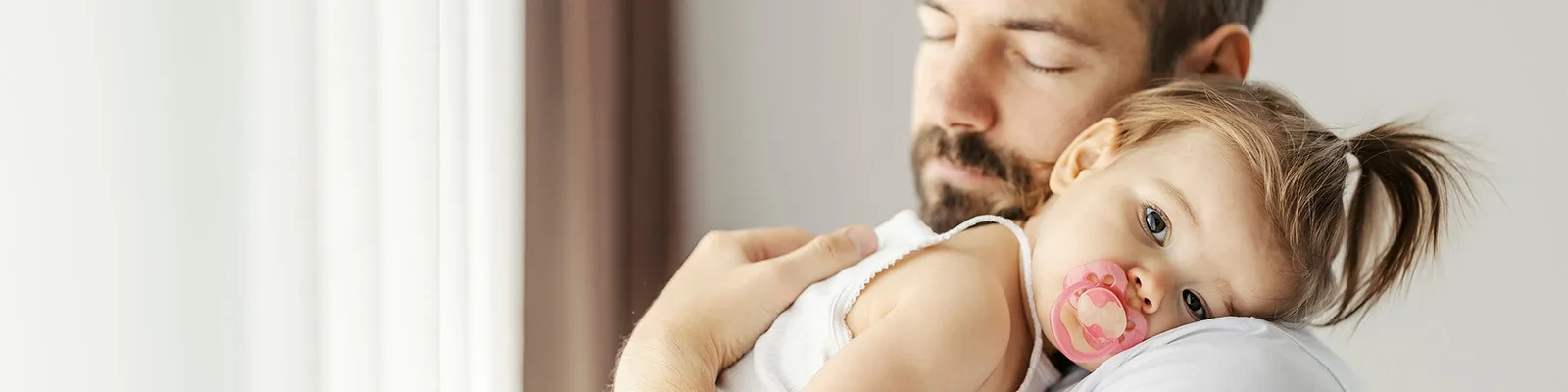 Toddler resting on father's shoulder
