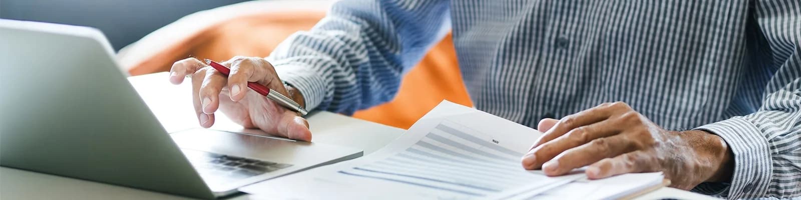 Man working on documents and typing on laptop