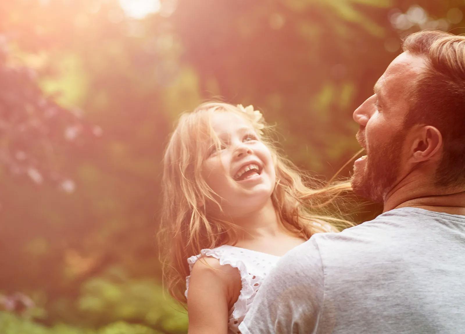 Father and daughter laughing outside
