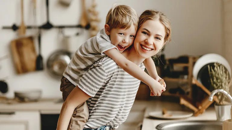 Happy mother and toddler son in kitchen
